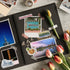 'Huntsville' and 'ALABAMA' stickers on a black scrapbook page with travel photos and tulips