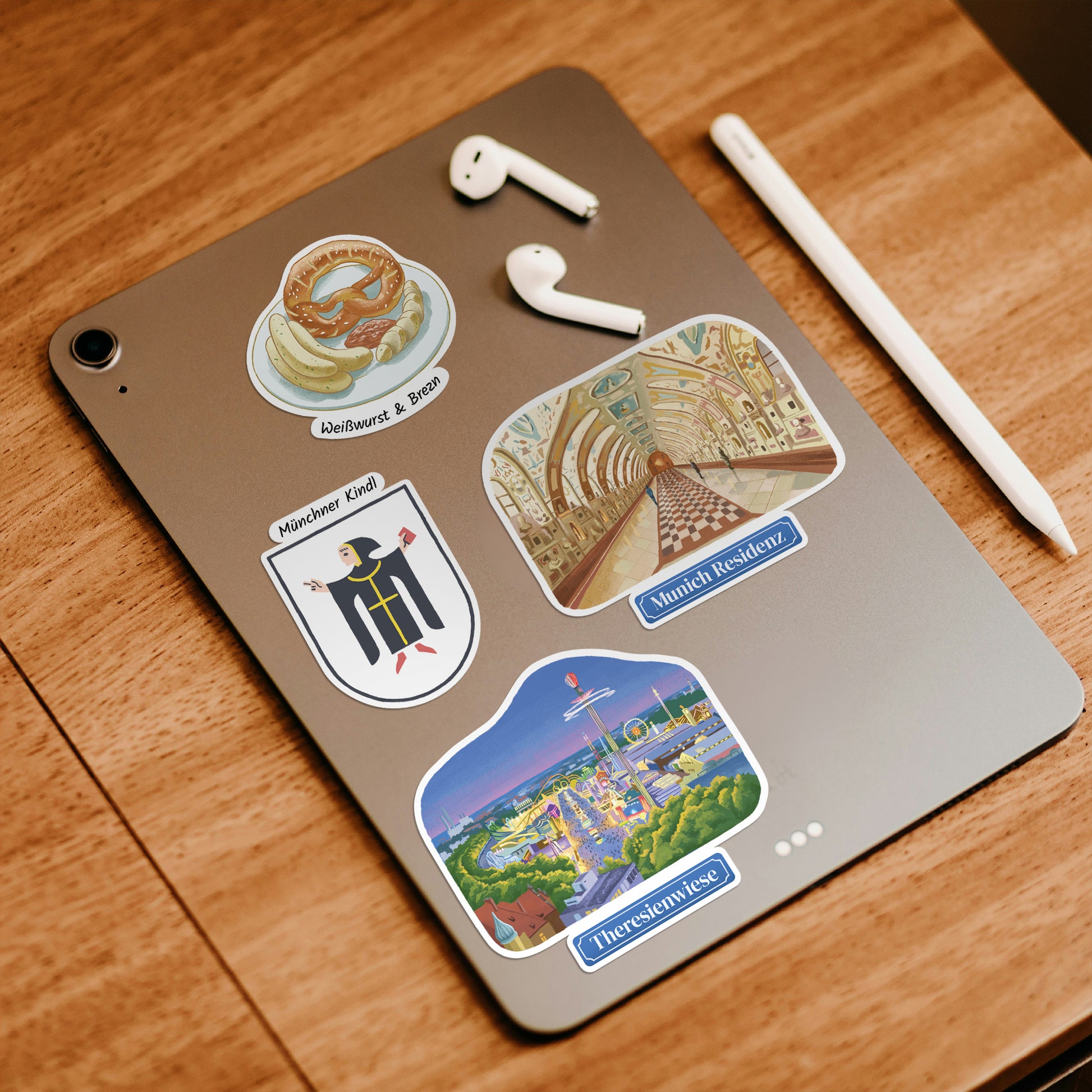 Pretzel with Weisswurst, Muenchner Kindl, Munich Residenz and Theresienwiese stickers on a grey tablet