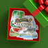 A gift box with a red interior displaying a Panama-themed collage sticker or decal featuring landmarks, the Panama flag, and the word PANAMA. A green gift box with a red ribbon is partially visible in the upper right on a green background.