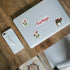 "Turkiye", tulip stamp and camel stickers on a silver laptop lid beside a marble phone case