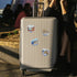 Champagne hard suitcase with Santorini stickers of Red Beach, Ancient Akrotiri and a blue-domed church