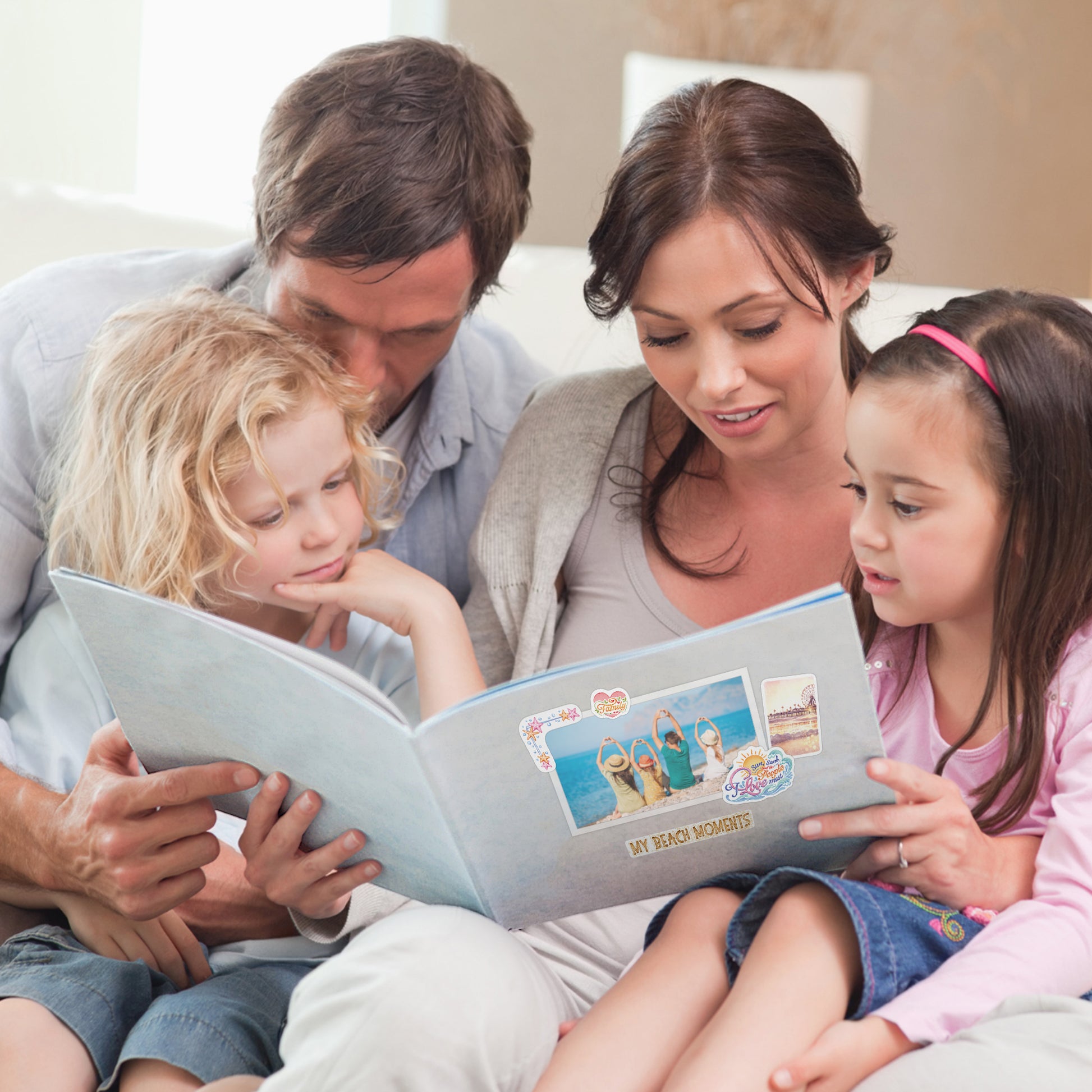 A family reading a photo album with beach stickers on the page headed 'My Beach Moments'
