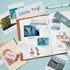 A styled flat-lay of a scrapbook or journal page featuring travel-themed cutouts and printed cards, including a large 'Chile Trip!' note, a ticket stub, a 'STGO' stamp, and small travel photos, arranged on a light blue background with a pen nearby.